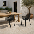 Terrace pair | two matte-black open-mesh armchairs shown together at an outdoor dining table