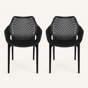 Studio front | two matte-black open-mesh armchairs, front view, on a warm-white studio ground