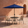 In a room | navy octagonal umbrella over black cafe table in terracotta courtyard with two chairs