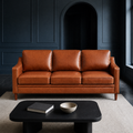 Blue room | Chestnut three-seat sofa facing forward against dark blue paneled walls with a low black coffee table