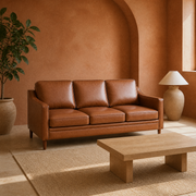 Terracotta room | Chestnut three-seat sofa at an angle in a terracotta-plaster room with a pale wood table